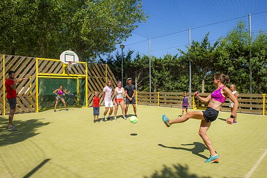 Familia jugando fútbol en cancha multisport en camping CAPFUN Emeraude en Portiragnes (34).