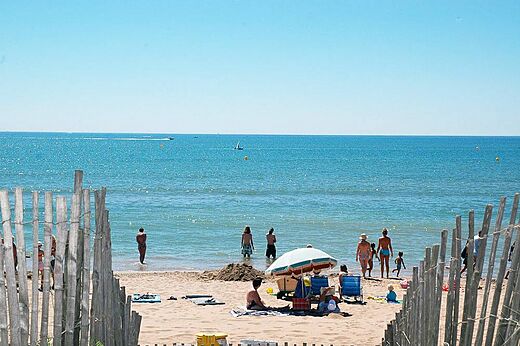 Playa de arena fina con bañistas y sombrilla en CAPFUN Emeraude, Portiragnes (34).