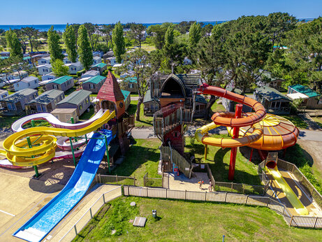 Toboganes acuáticos coloridos y área de juegos en el camping CAPFUN Grand Large en FOUESNANT (29).
