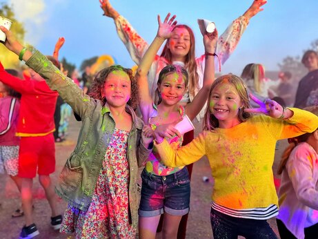 Niños sonrientes cubiertos de polvo de colores en una animación en el camping CAPFUN Grand Large en FOUESNANT (29).