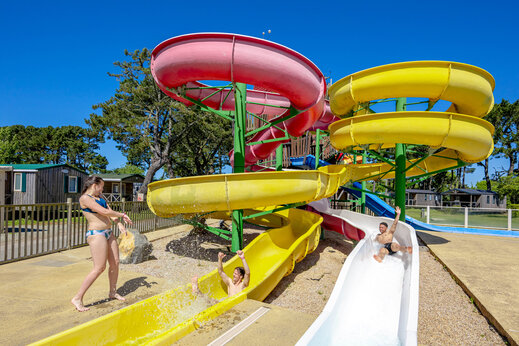Toboganes acuáticos coloridos y juegos de agua en el camping CAPFUN Grand Large en FOUESNANT (29).