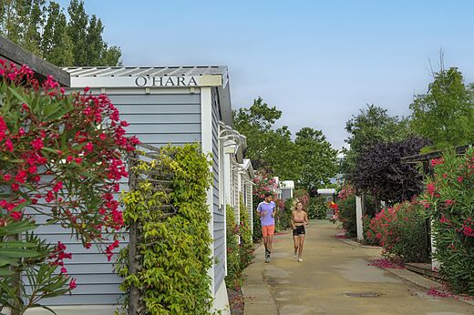 Modernos Mobil-homes y camino florido en camping CAPFUN Hermitage SERIGNAN (34).