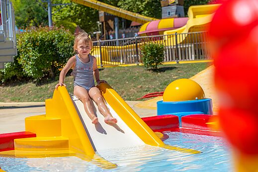 Niña en tobogán acuático en el camping CAPFUN Imbours en LARNAS (07).