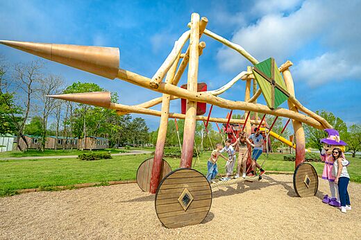 Área de juegos de madera con niños en el camping CAPFUN Mirabelle en VOLSTROFF (57).