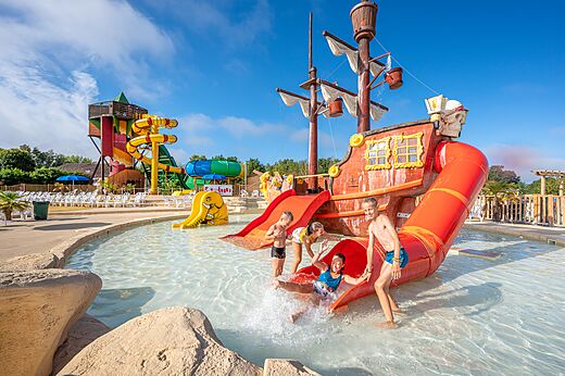 Toboganes acuáticos, barco pirata y niños en el camping CAPFUN Paradis de Bazas a BAZAS (33).