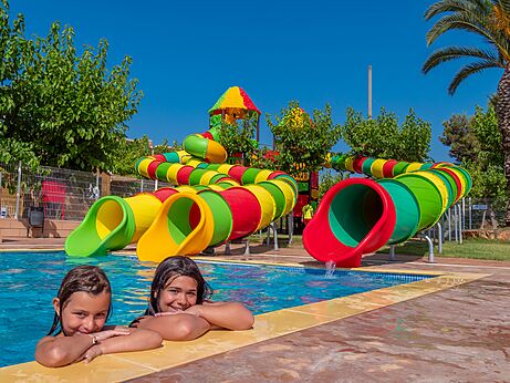 Piscina exterior con toboganes acuáticos coloridos y niños en el camping CAPFUN Alba en CREIXELL (43).