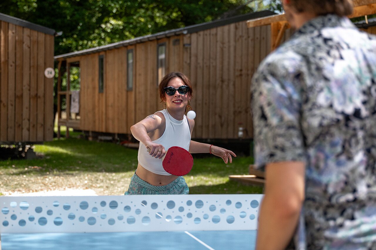 Mujer sonriente jugando al tenis de mesa en el camping CLICOCHIC Aloua en Sevrier (74).