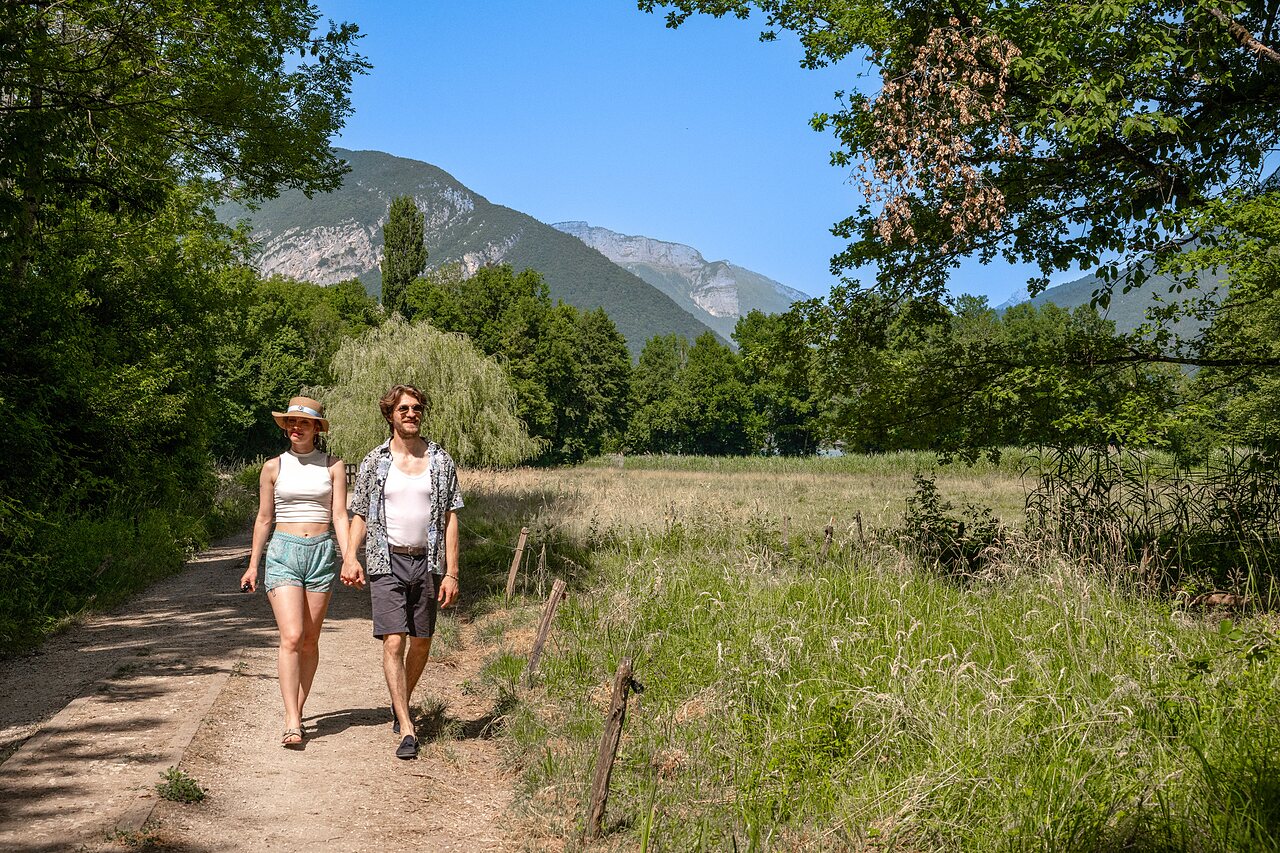 Pareja paseando por sendero natural, montañas en camping CLICOCHIC Aloua en Sevrier (74).