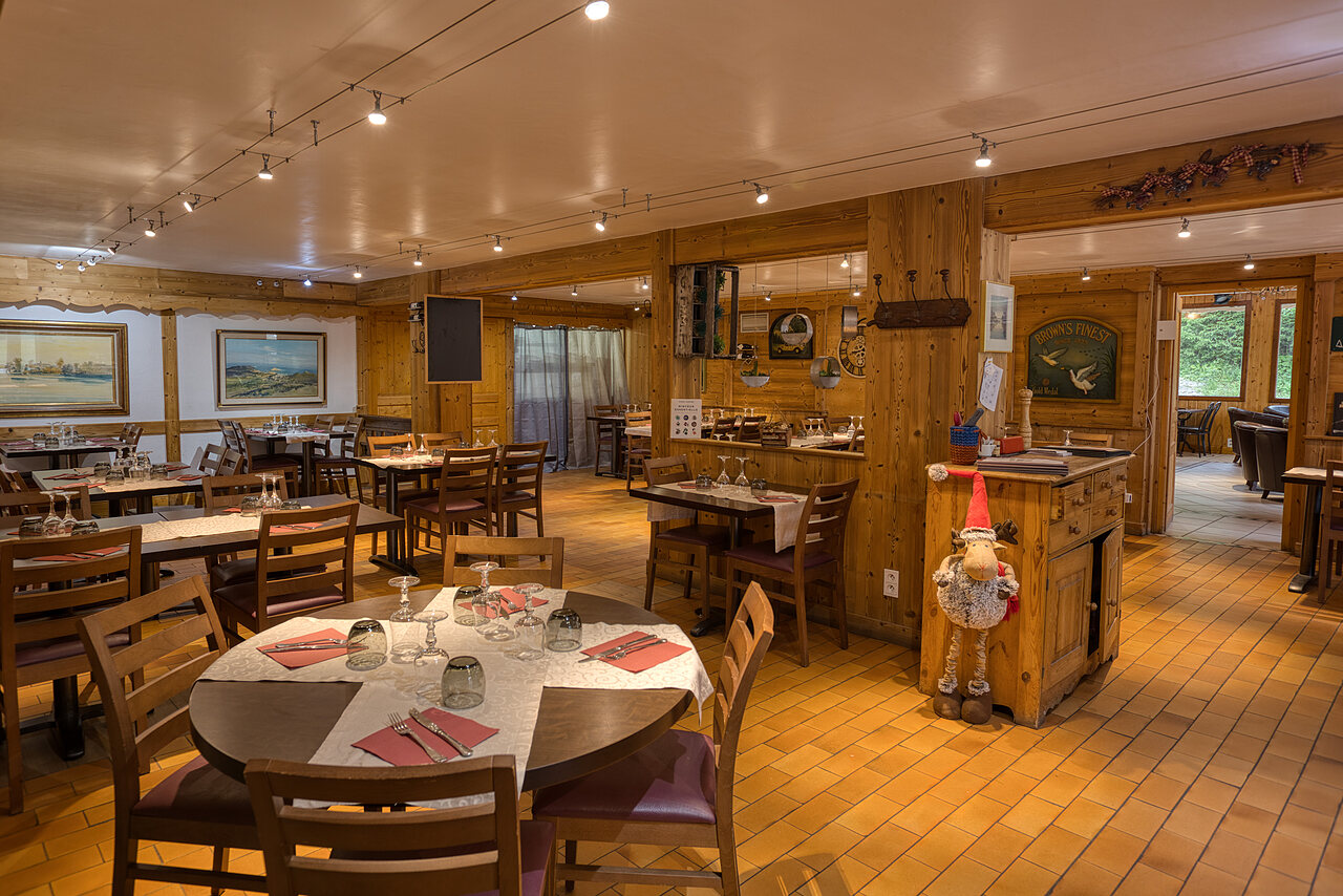 Acogedor comedor con mesas preparadas en el camping CLICOCHIC Alpes Lodges en Pralognan la Vanoise (73).