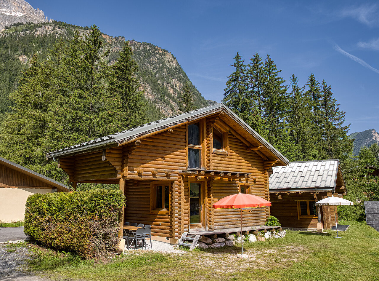 Chalet de madera con terraza y sombrilla, monta�as en el camping CLICOCHIC Alpes Lodges en Pralognan la Vanoise (73).