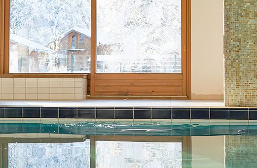 Piscina interior, vista nevada en el camping CLICOCHIC Alpes Lodges en Pralognan (73).