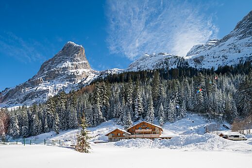 Montañas nevadas, alojamientos de madera en el camping CLICOCHIC Alpes Lodges en Pralognan la Vanoise.
