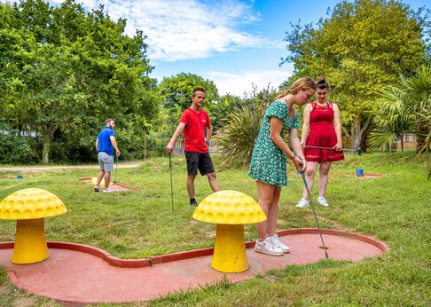 Familia jugando minigolf en un campo exterior en el camping CAPFUN An Trest en SARZEAU (56).