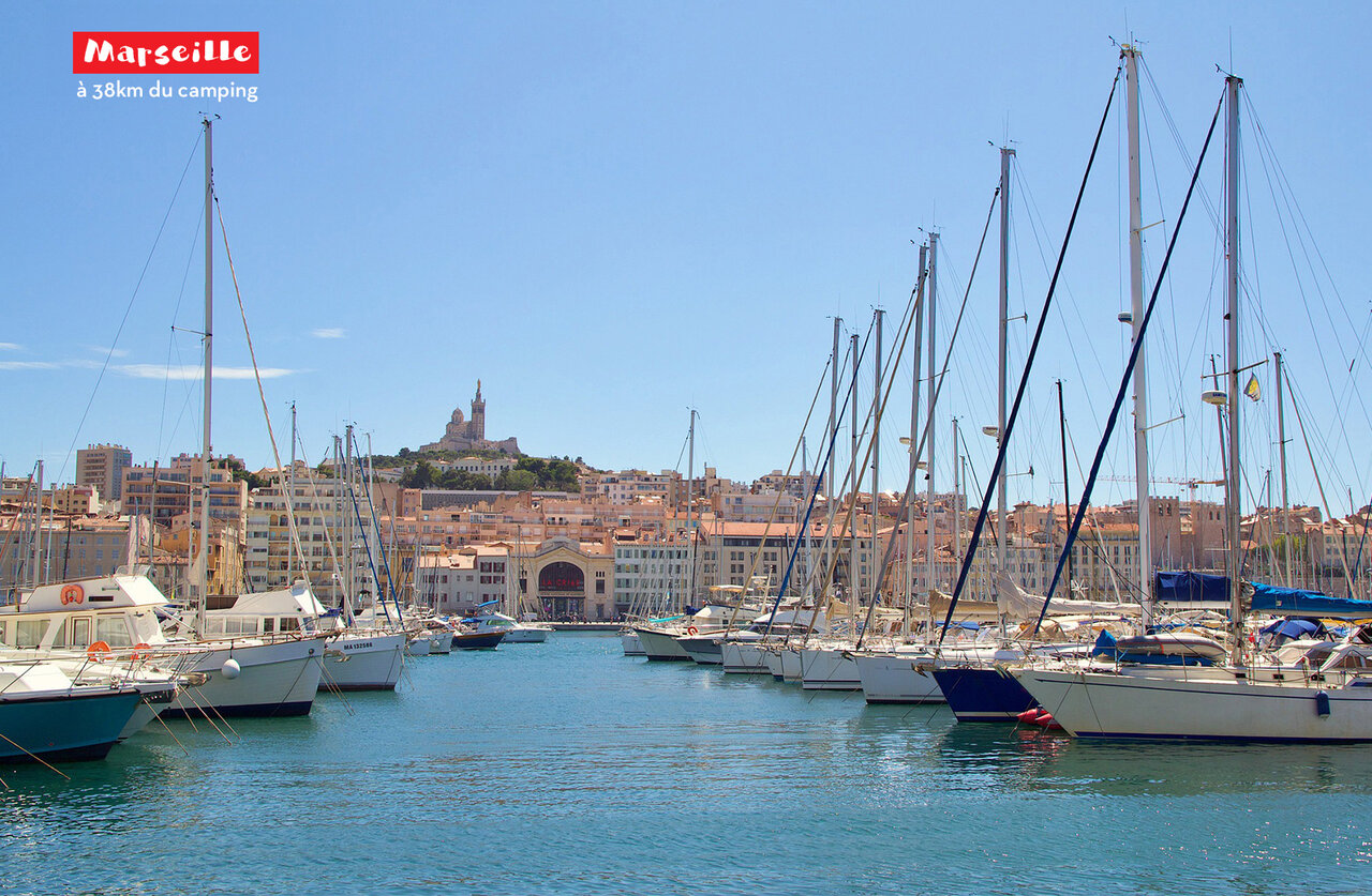Puerto Viejo de Marsella con barcos y Notre-Dame de la Garde, lugar para visitar.