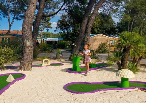 Mini-golf colorido con ni�a sonriente en el camping CAPFUN Arbois du Castellet en LE CASTELLET (83).
