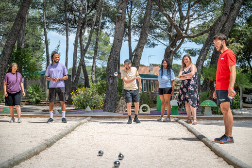 Grupo de amigos jugando a la petanca en una cancha en el camping CAPFUN Arbois du Castellet en LE CASTELLET (83).