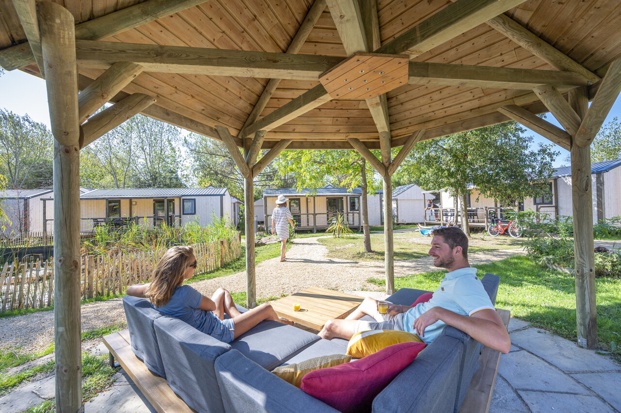 Pareja relaj�ndose bajo cenador, casas m�viles en CAPFUN Armor H�ol en Piriac sur Mer.