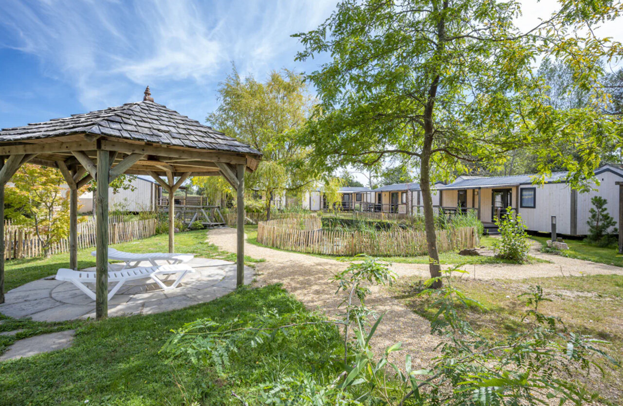 Cenador de madera, tumbonas y casas m�viles en el camping CAPFUN Armor H�ol en Piriac sur Mer (44).