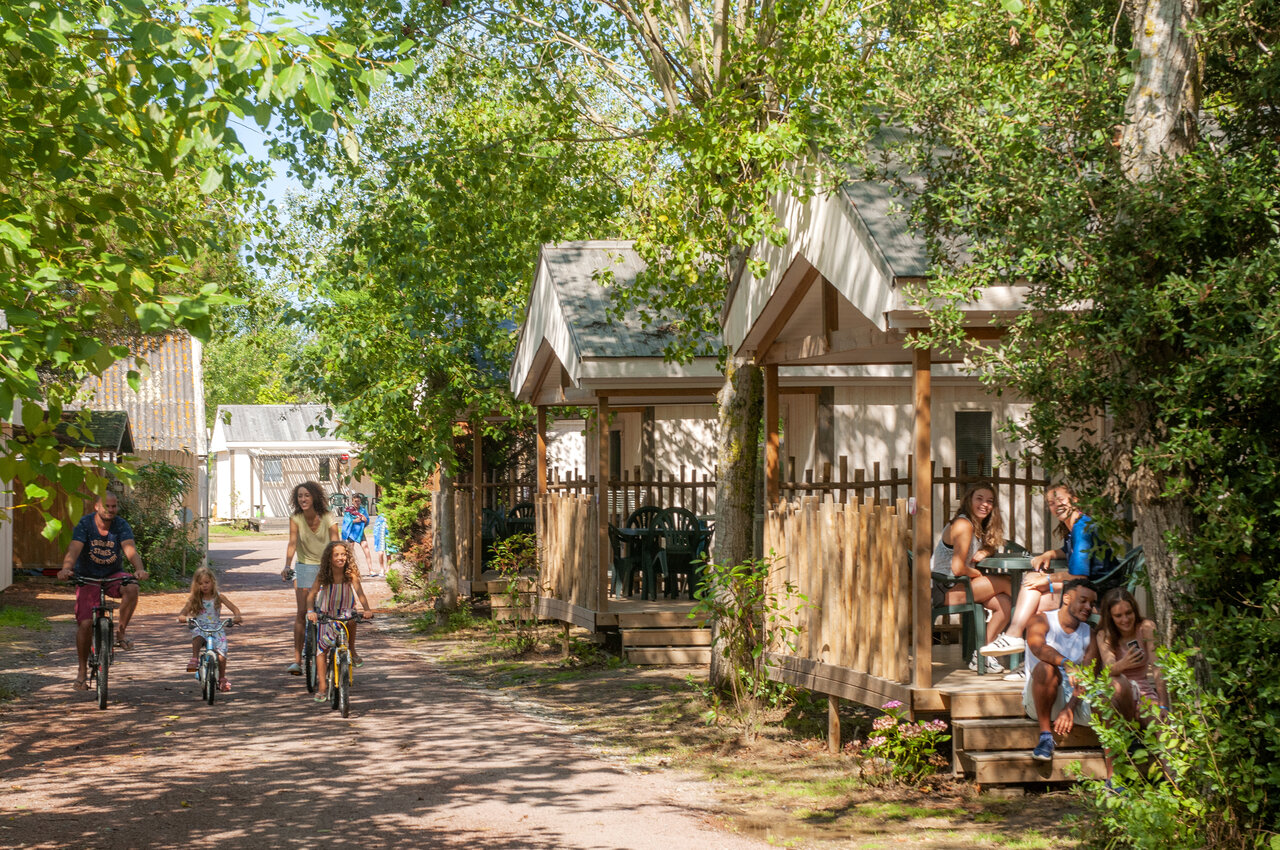 Familia en bicicleta y alojamientos chalets en el camping CAPFUN Armor H�ol en Piriac sur Mer (44).