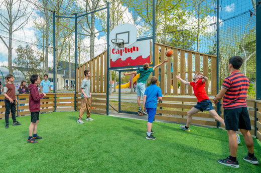 Campo multideportivo con jóvenes jugando baloncesto en camping CAPFUN Armor Héol.