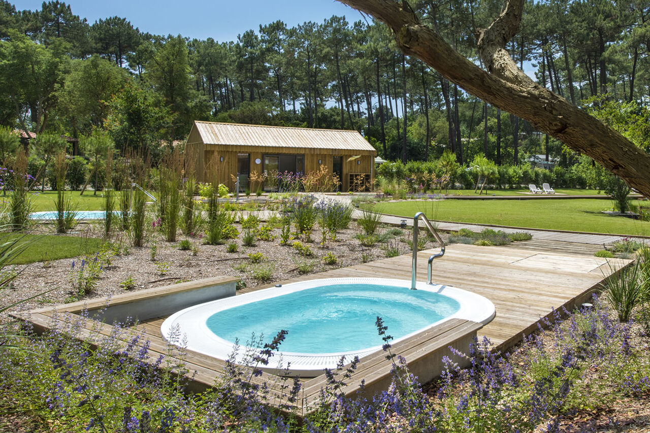 Jacuzzi exterior y zona de relajaci�n en el camping LIBRANOO Naturiste Arnaoutchot en Veille-Saint-Girons, Landes, Francia.