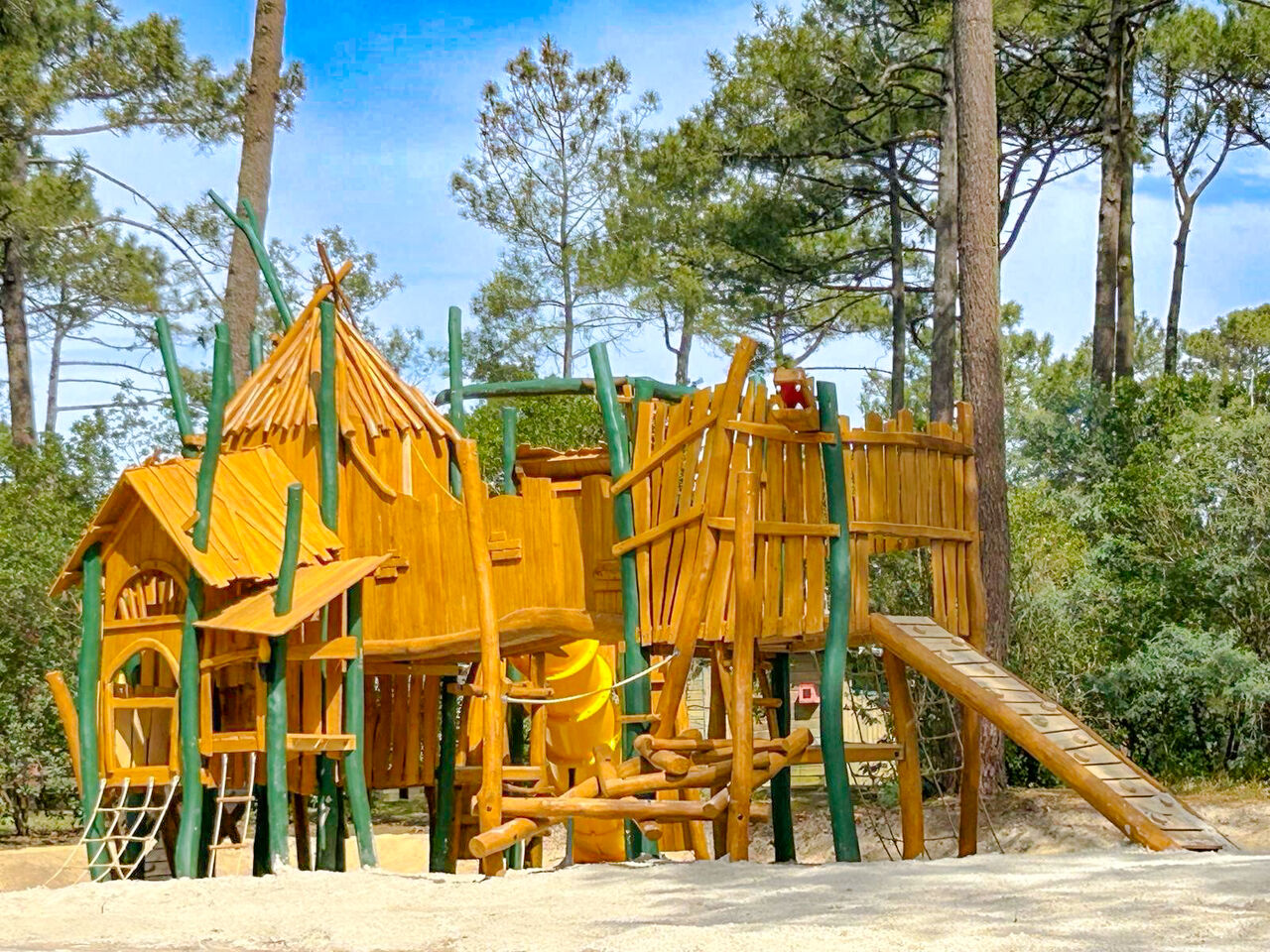 Gran estructura de juegos de madera con tobog�n y redes en el camping LIBRANOO Naturiste Arnaoutchot en Veille-Saint-Girons, Landes, Francia.