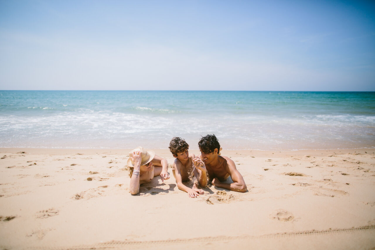 Familia naturista disfrutando de la playa de arena fina en el camping LIBRANOO Naturiste Arnaoutchot en Veille-Saint-Girons, Landas, Francia.
