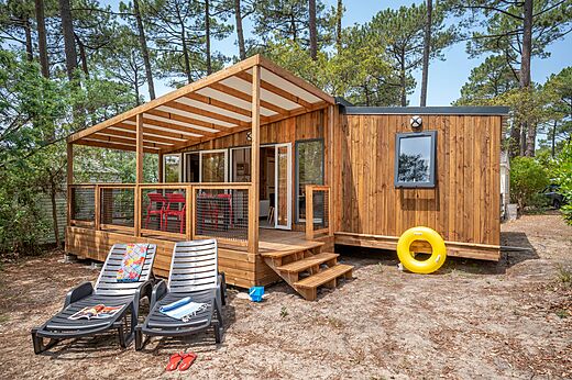 Mobil-home de madera moderno con terraza cubierta en el camping LIBRANOO Naturiste Arnaoutchot en Veille-Saint-Girons, Landas, Francia.