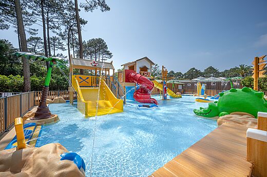 Piscina l�dica, toboganes y juegos infantiles en el camping LIBRANOO Naturiste Arnaoutchot en Veille-Saint-Girons, Landes, Francia.