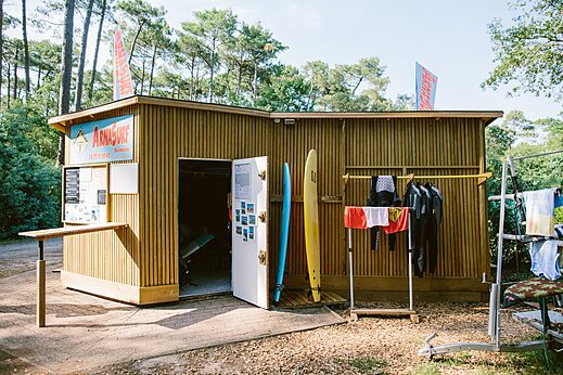 Escuela de surf con tablas y trajes de neopreno en el camping LIBRANOO Naturiste Arnaoutchot en Veille-Saint-Girons, Landes, Francia.
