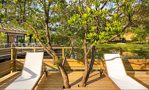 Zona relax spa, terraza de madera y �rboles en el camping LIBRANOO Naturiste Arnaoutchot en Veille-Saint-Girons, Landas, Francia.