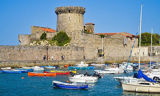 Puerto hist�rico con barcos coloridos y fortaleza medieval, para visitar cerca del camping.