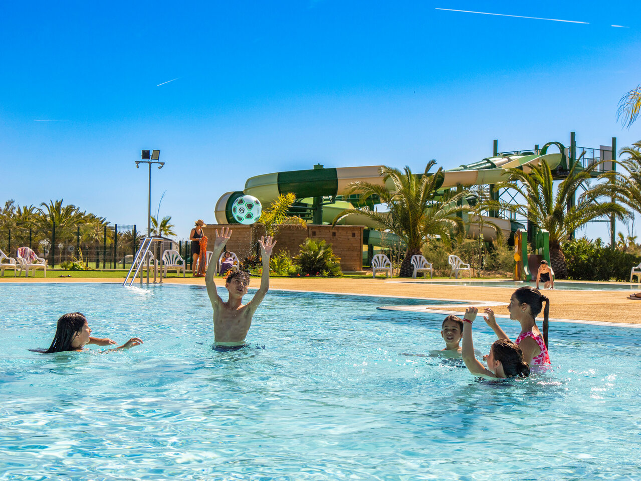 Piscina exterior, toboganes y ni�os jugando en camping CAPFUN Aube, Tarragona.