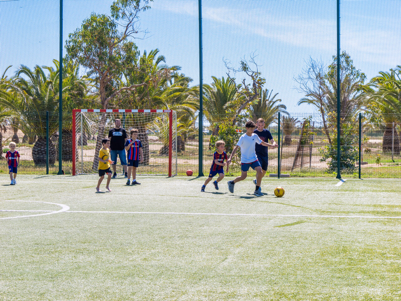 Ni�os jugando f�tbol en campo multideporte en camping CAPFUN Aube en Deltebre, Tarragona.