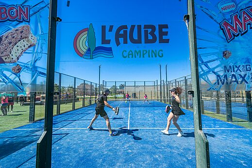 Cancha de pádel azul con jugadores en el camping CAPFUN Aube en Deltebre, Tarragona.