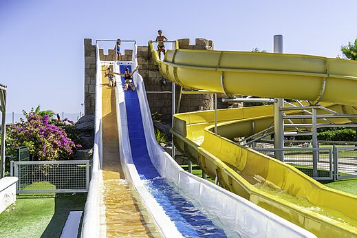 Toboganes acuáticos coloridos con niños divirtiéndose en el camping CAPFUN Aube en Deltebre, Tarragona.