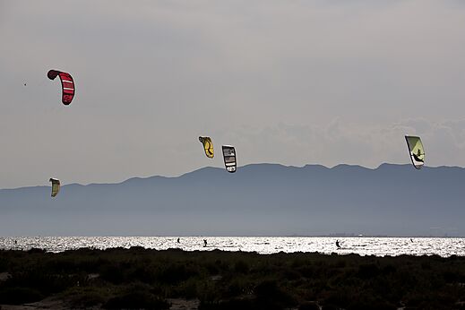 Kitesurfistas en el agua con monta�as al fondo en el camping CAPFUN Aube en Deltebre, Tarragona (43).