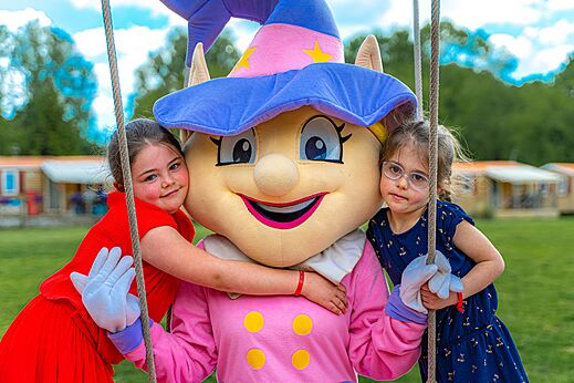 Mascota del camping y dos niños sonrientes en el camping CAPFUN Aube en Deltebre, Tarragona.