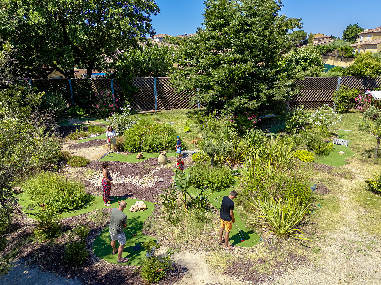 Campo de minigolf ajardinado con familias jugando en camping CAPFUN Aubr�des en Puget sur Argens (83).