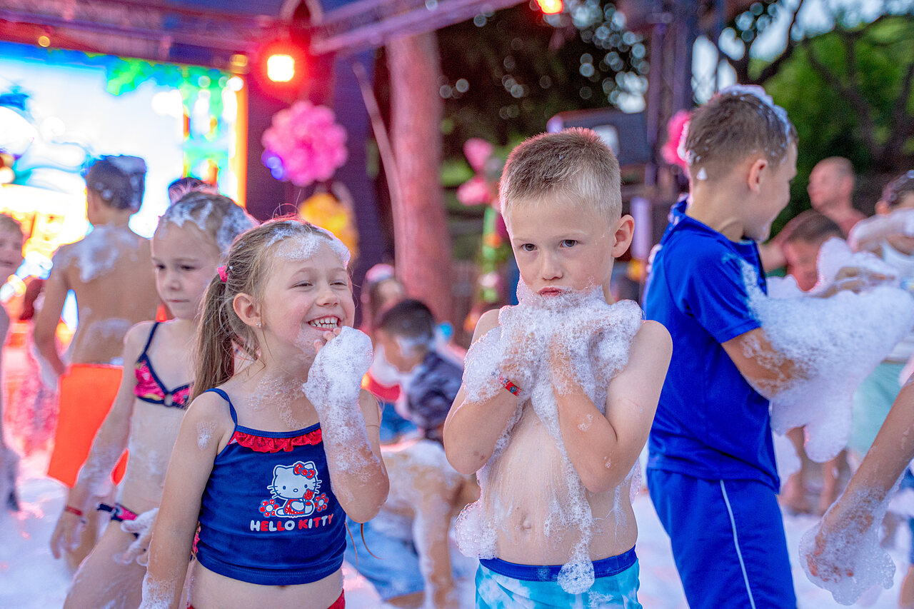 Ni�os felices jugando en la espuma durante una fiesta de animaci�n en el camping CAPFUN Aubr�des en Puget sur Argens (83).
