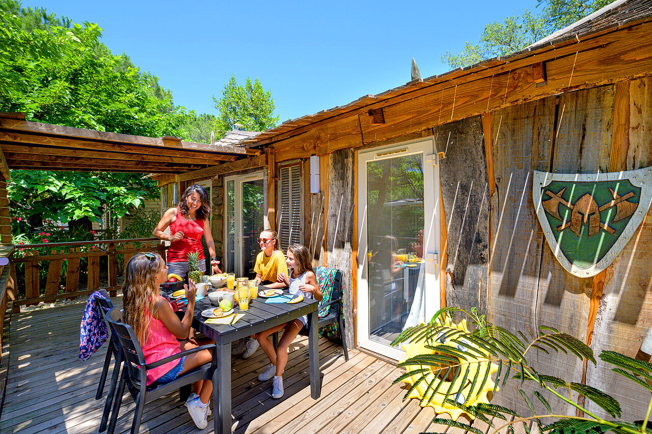Chalet, familia desayunando en terraza en camping CAPFUN Aubr�des en Puget sur Argens.
