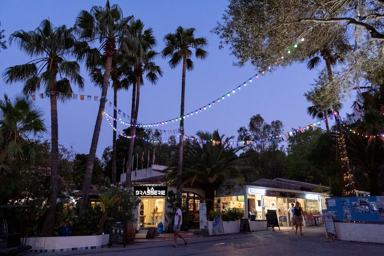 Restaurante y bar iluminados, guirnaldas festivas en el camping CLICOCHIC Baie de Cavalaire (83).
