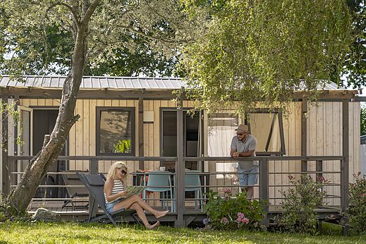 Casa m�vil moderna con terraza, pareja relaj�ndose en camping CLICOCHIC Baie de Douarnenez.