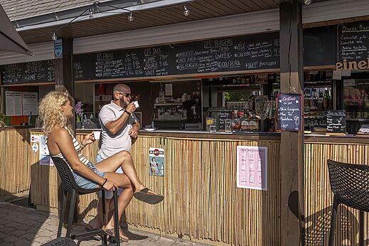 Bar y restaurante con clientes en el camping CLICOCHIC Baie de Douarnenez en Poullan-sur-Mer (29).