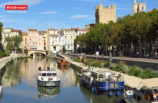 Canal de la Robine, barcos y edificios históricos en Narbonne, Occitania.