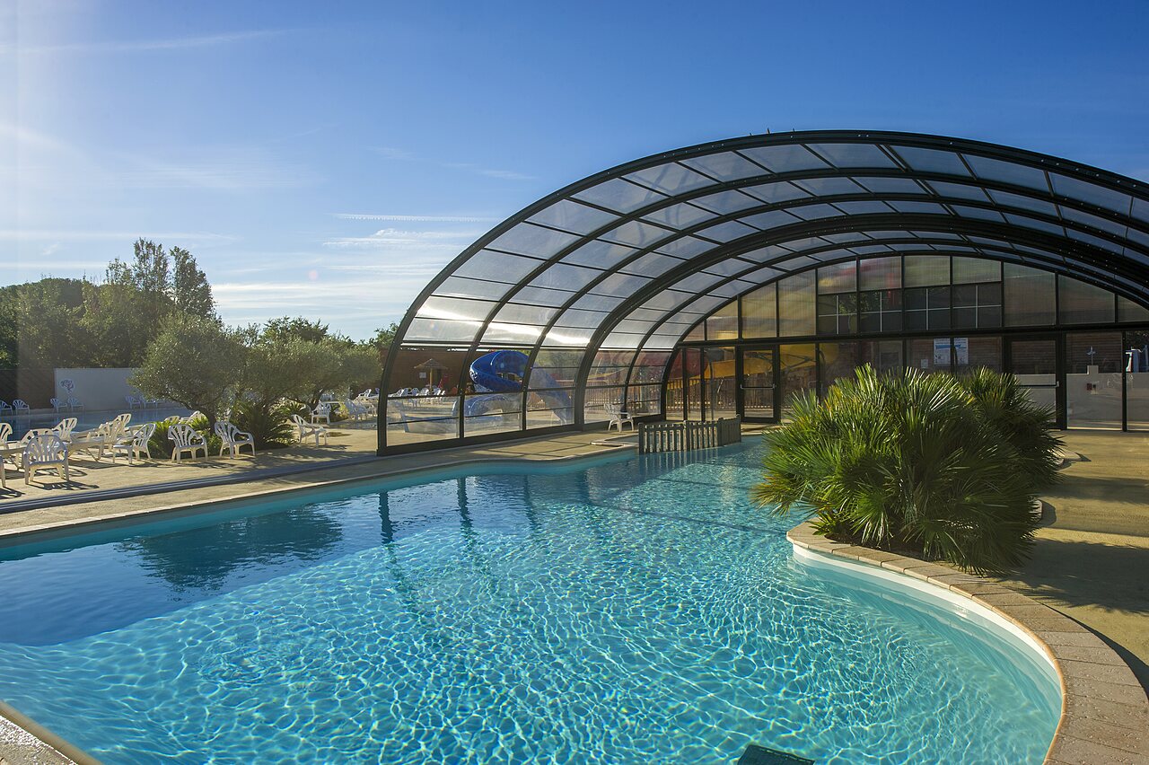 Piscina exterior y cubierta con toboganes en el camping CAPFUN Bastide en N�mes (30).