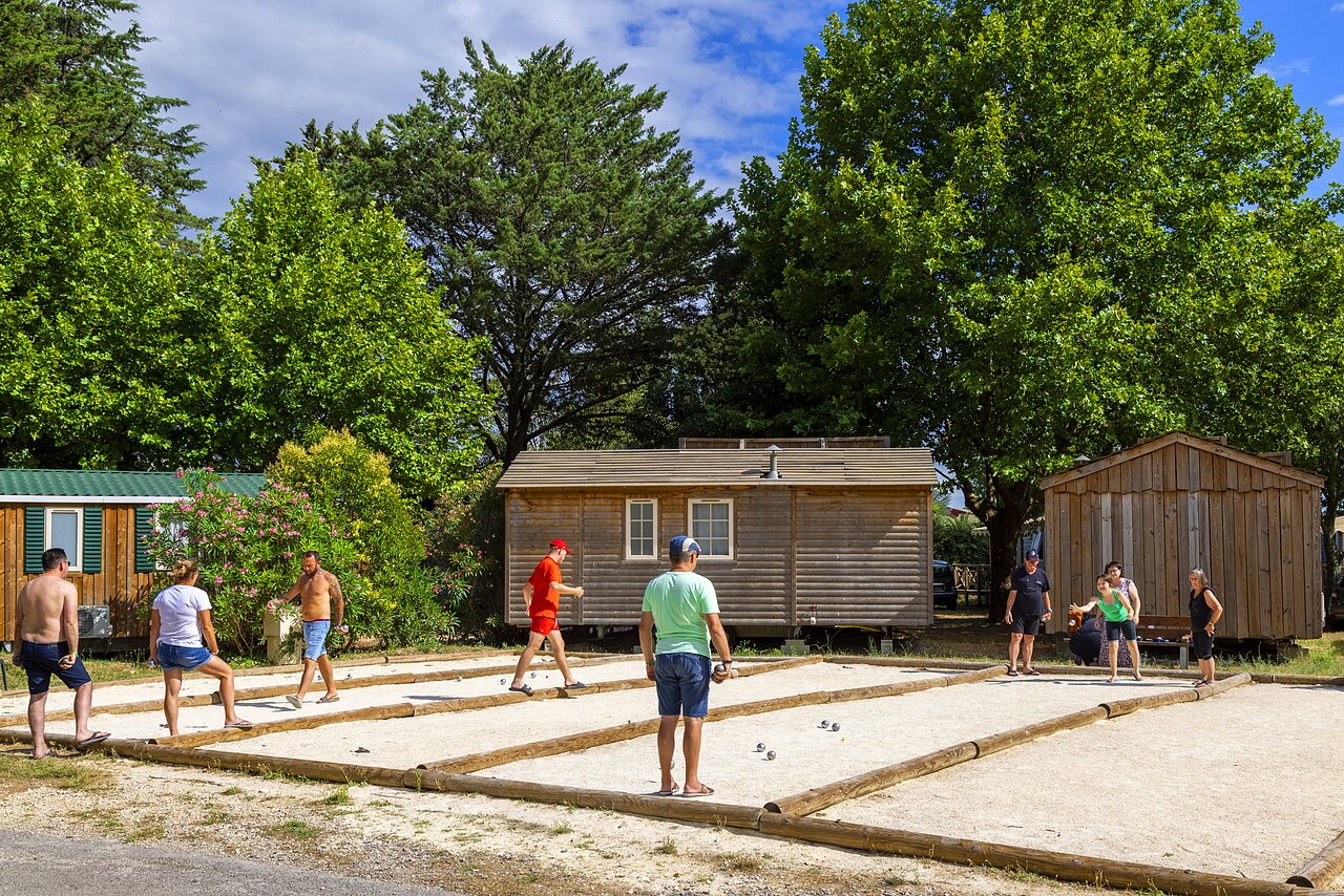 Cancha de petanca animada con varios jugadores en el camping CAPFUN Bastide en N�mes (30).