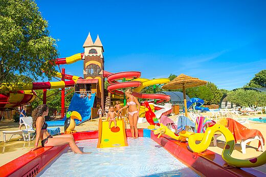 Parque acuático con toboganes coloridos y piscina infantil en el camping CAPFUN Bastide en Nîmes (30).