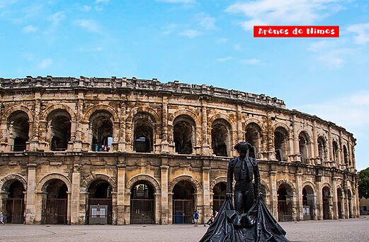 Arenas de Nimes, histórico anfiteatro romano con estatua de torero, Gard.