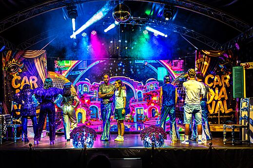 Espectáculo de carnaval colorido con artistas en el escenario en el camping CAPFUN Bastide en Nîmes (30).